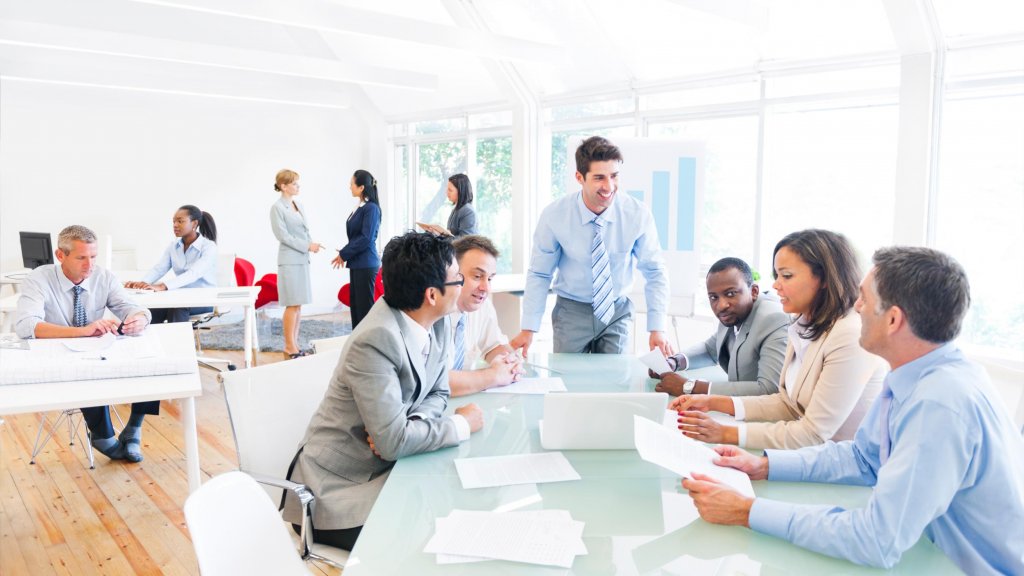 Employees engaging over a board room table
